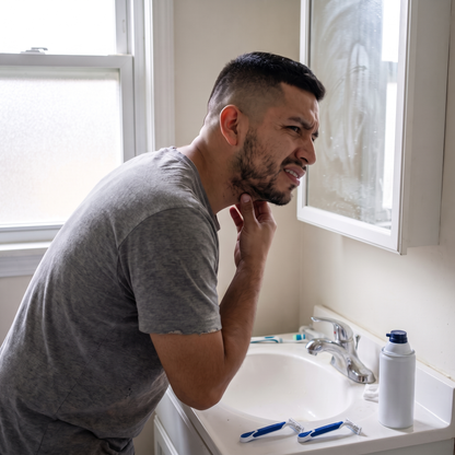 Hombre frente al espejo revisando su barba crecida